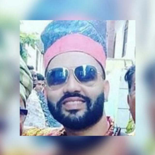 Pai Edmilson de Ogum sorrindo, com traje tradicional.