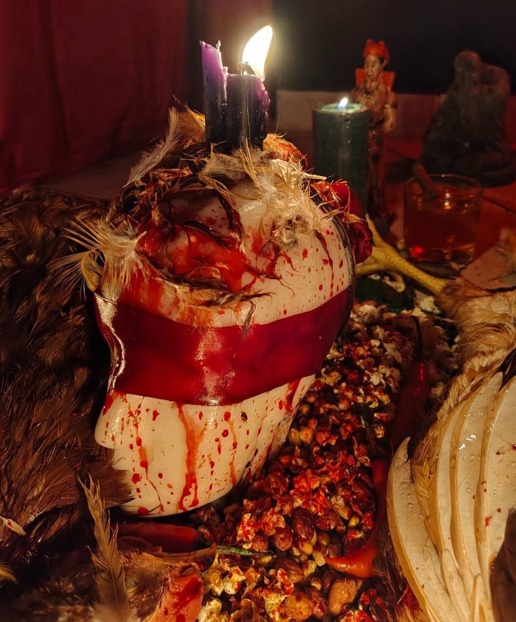 Elementos de ritual com velas, penas e oferendas.