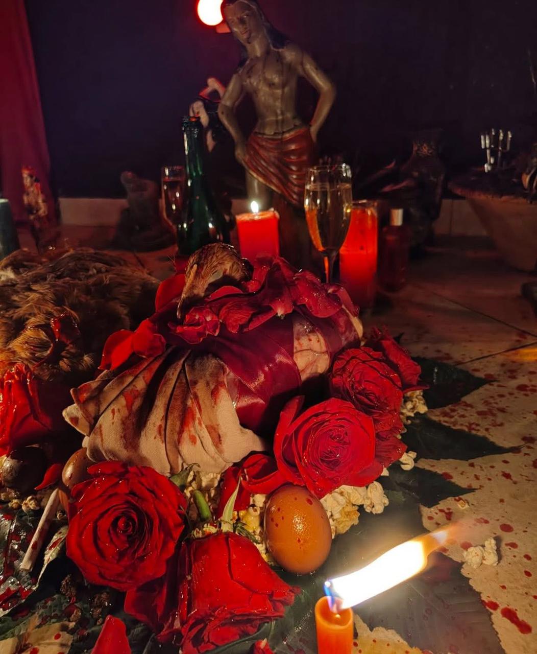 Altar com rosas vermelhas, ovo e velas para trabalho de amor.