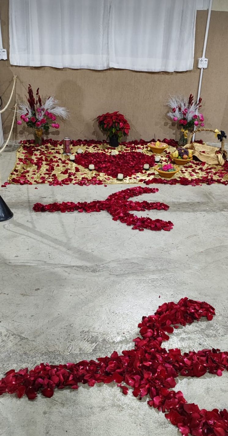 Trabalho espiritual com pétalas vermelhas formando símbolos no chão.